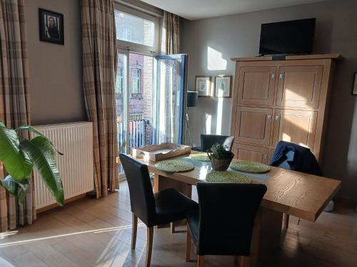 - une salle à manger avec une table et des chaises en bois dans l'établissement Suite L'Ane city center & parking, à Bruges