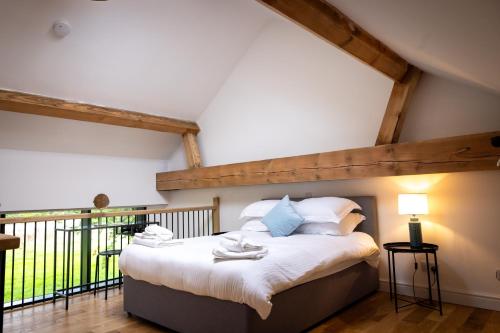 Schlafzimmer mit einem Bett mit weißer Bettwäsche und blauen Kissen in der Unterkunft Beaumont Mews in St Albans