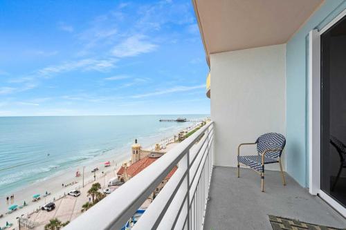 a balcony with a chair looking out at the beach at Luxury 11th Floor 1 BR Condo Direct Oceanfront Wyndham Ocean Walk Resort Daytona Beach | 1107 in Daytona Beach