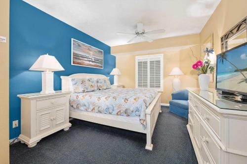 ein Schlafzimmer mit einem Bett und einer blauen Wand in der Unterkunft Luxury 6th Floor 1 BR Condo Direct Oceanfront Wyndham Ocean Walk Resort Daytona Beach | 609 in Daytona Beach