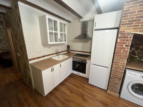 a white kitchen with a sink and a refrigerator at Apartamento Rural Piedra in Jérica