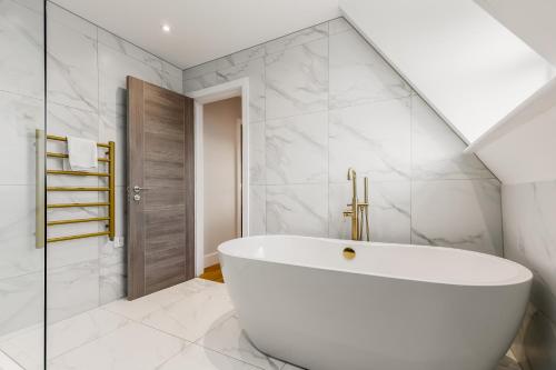 a bathroom with a white tub and a shower at Tower House Apartments in Bournemouth