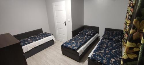 mały pokój z 2 łóżkami i szafą w obiekcie Przytulny Zakątek w mieście Żerniki Wroctawskie