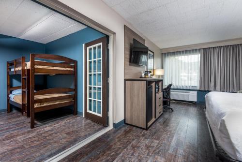 a hotel room with a bunk bed and a kitchen at Baymont by Wyndham Bartonsville Poconos in Bartonsville