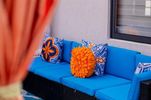 a blue couch with pillows and a orange at Emerald SunDara Villa Ochi in Ocho Rios