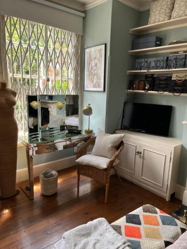 uma sala de estar com uma televisão e uma janela em Dawn and Dudley the Sausage dog's Parkside Home em Londres