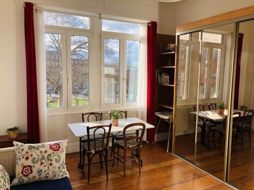 une salle à manger avec une table et des chaises et une fenêtre dans l'établissement 4 étoiles Magnifique Neustadt - Spacieux, Central & Élégant avec balcon et belle vue, à Strasbourg