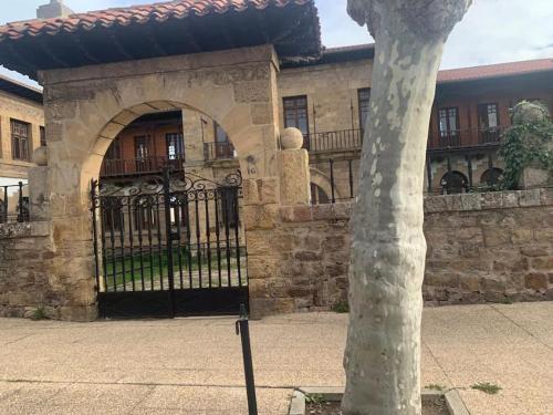 a building with a gate and a tree in front of it at Apartament 3 Bedrooms 80m2 Alto Campoo Reinosa Cantabria in Reinosa