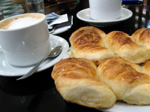 里瓦達維亞海軍準將城的住宿－Hotel Urbano Ventia，一盘羊角面包和一杯咖啡