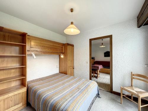 une chambre avec un lit, un miroir et une chaise dans l'établissement Appartement cosy au pied des pistes à Combloux avec balcon et casier à skis - FR-1-560-61, à Combloux