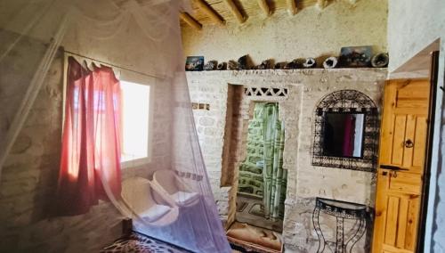 a room with a room with a window and a mirror at Kasbah Dar Talouste in Afela nʼIsly