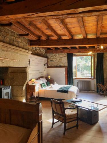 une chambre avec un lit et une table dans une pièce dans l'établissement Le petit château du Villard, à Le Malzieu Forain