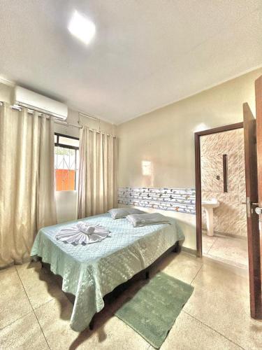 a bedroom with a bed and a window at Hotel Económico in Campo Grande