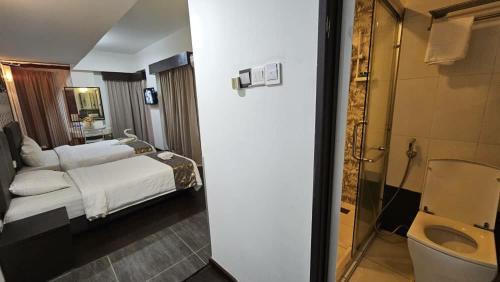 a hotel room with a bed and a bathroom at Warisan Hotel Kota Kinabalu in Kota Kinabalu