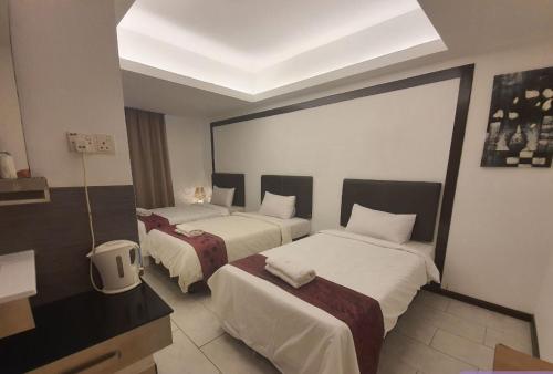 a hotel room with two beds and a window at Warisan Hotel Kota Kinabalu in Kota Kinabalu