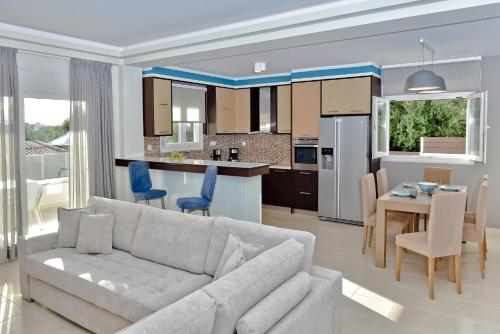 een woonkamer en een keuken met een bank en een tafel bij Serenity Retreat , By IdealStay Experience in Gournes