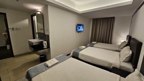 a hotel room with two beds and a mirror at Warisan Hotel Kota Kinabalu in Kota Kinabalu