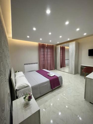 a bedroom with a bed and a table with flowers on it at Villa Abenante Pompei in Scafati