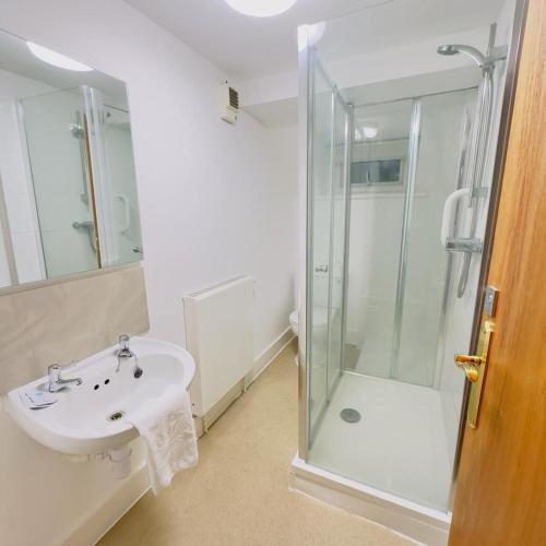 a bathroom with a sink and a shower at The Elder Grove Epsom in Epsom