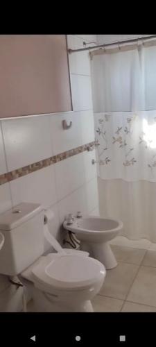 a white bathroom with a toilet and a sink at Cabaña Dina in Santa Rosa del Conlara