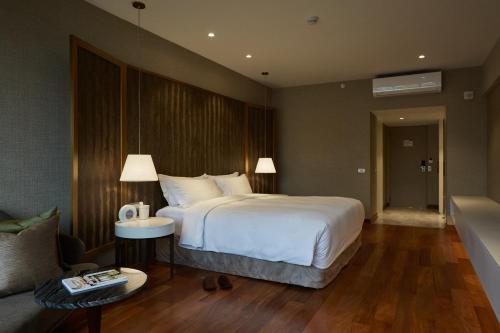 a bedroom with a large white bed and a couch at Manto Hotel Lima - MGallery Collection in Lima