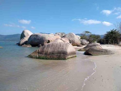 a group of rocks in the water on a beach at Caminho do Mar Ap 4 in Governador Celso Ramos