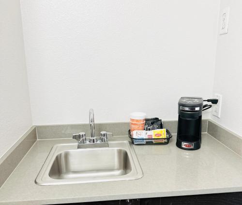 a kitchen counter with a sink and a coffee maker at Comfort Inn & Suites Frisco - Plano in Frisco