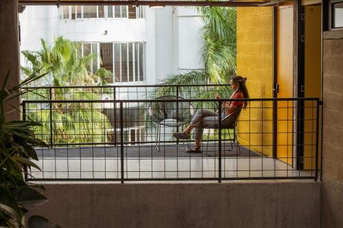 a woman sitting on a chair on a balcony at Hotel Cytrico in Medellín