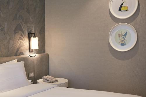 a bedroom with a bed and a toilet and plates on the wall at Manto Hotel Lima - MGallery Collection in Lima