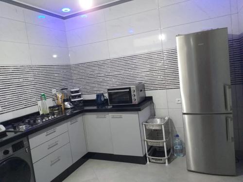 eine Küche mit einem Kühlschrank und einer Mikrowelle in der Unterkunft ajdir/contron in Ochenene