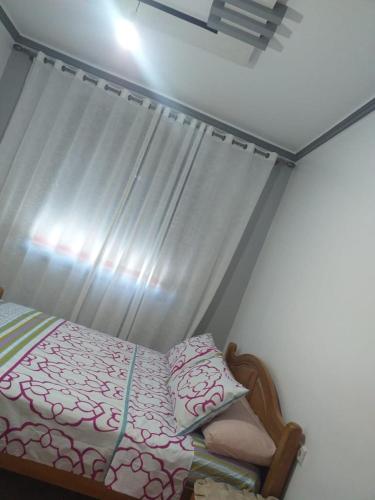 ein Schlafzimmer mit einem Bett mit einem Vorhang und einem Fenster in der Unterkunft ajdir/contron in Ochenene