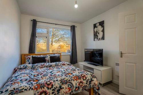a bedroom with a bed and a tv and a window at Stylish 2 bedroom apartment in Birmingham in Birmingham