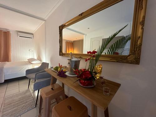 a room with a mirror and a table with flowers at Suite by Villa Serena - Manapany les bains in Saint-Joseph