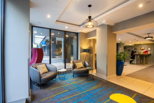 a lobby with two chairs and a table at City Sleeper at Royal National Hotel in London