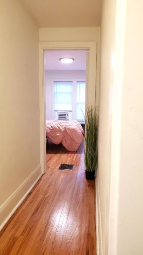 a room with a bedroom with a bed and a wooden floor at Pinkston Gardens in Saint Paul