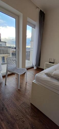 a bedroom with a bed and a chair and a window at Haas Apartments Downtown with Parking in Brno