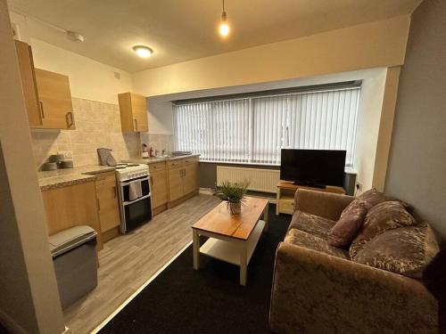 a living room with a couch and a table at Two bedroom apartment room 18 in Stockton-on-Tees