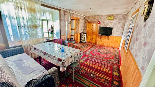 a living room with a table and a couch at Zaur Guest hause in Xınalıq