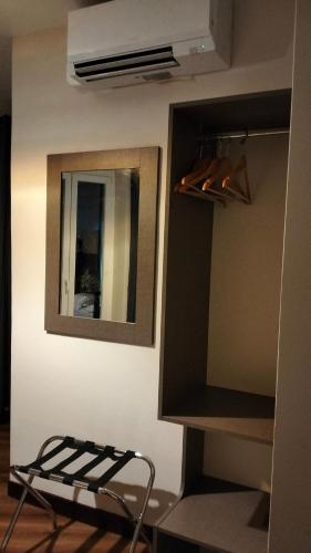 a room with a mirror on a wall and a shelf at HÔTEL ROYAL MONTREUIL in Montreuil