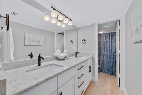a white bathroom with two sinks and a large mirror at Phoenix East II 2044 in Orange Beach