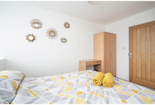 a bedroom with a bed with yellow slippers on it at MayDisc Long Stay Contractors in Portsmouth