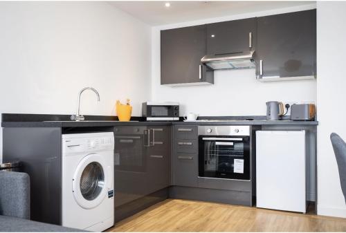a kitchen with a washing machine and a washer at MayDisc Long Stay Contractors in Portsmouth