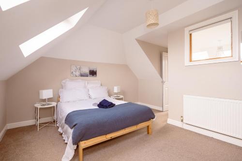 a white bedroom with a bed in a attic at Family home in central Guildford with Parking in Guildford