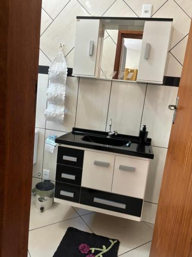 a bathroom with a sink and a mirror at Alojamento Araújo in Alto Caparao