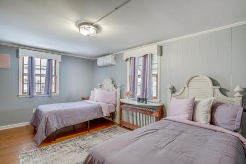 1 dormitorio con 2 camas, mesa y ventanas en Pet-Friendly Cambridge Home - Walk to River!, en Cambridge