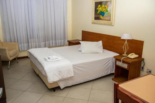 a hotel room with a bed and a telephone at Hotel Radar in Gravataí