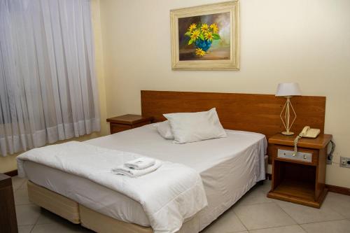 Habitación de hotel con cama y teléfono en Hotel Radar, en Gravataí