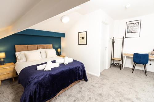 a bedroom with a large bed with a blue wall at Suite 6 - Double Room in the Heart of Oldham in Oldham