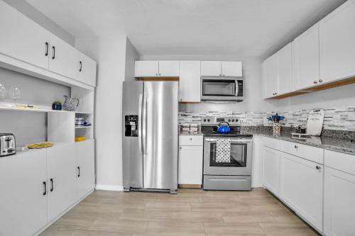 a kitchen with white cabinets and a stainless steel refrigerator at Cozy Plant City Home in Plant City