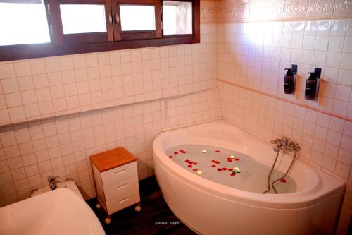 baño con bañera con flores en el suelo en Luxe ÁticoDúplex 2min Catedral, en Jaén